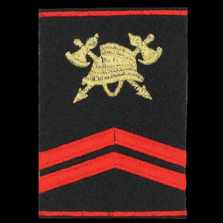 Black epaulet cover embroidered with a gold crossed axe fire crest and two red chevrons, made to a customer's own artwork.