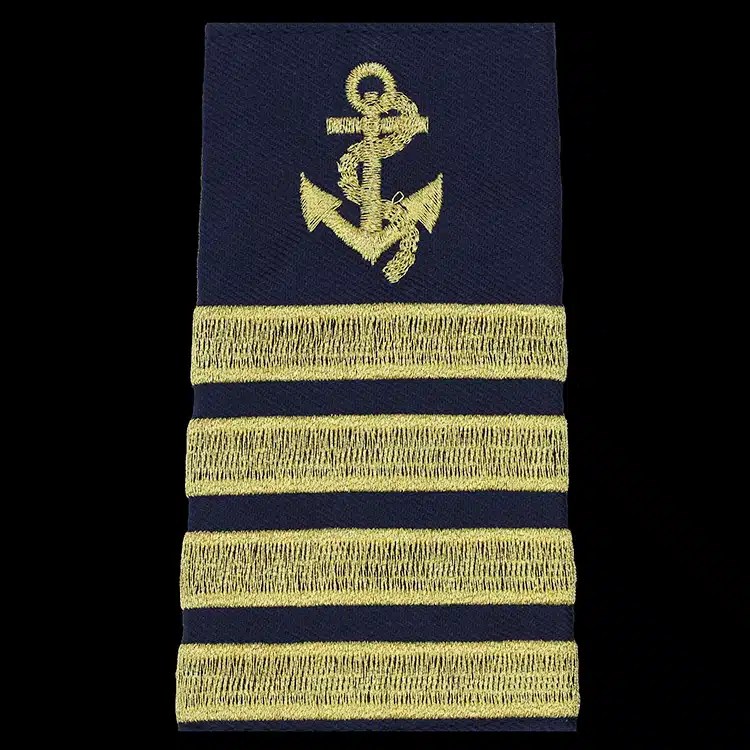 Navy epaulet cover embroidered with a gold metallic thread anchor above four gold braid bars.