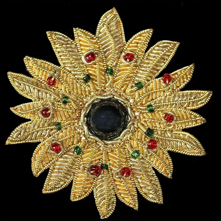 Hand embroidered gold bullion badge with a sunflower motif in red and green enamel stones.