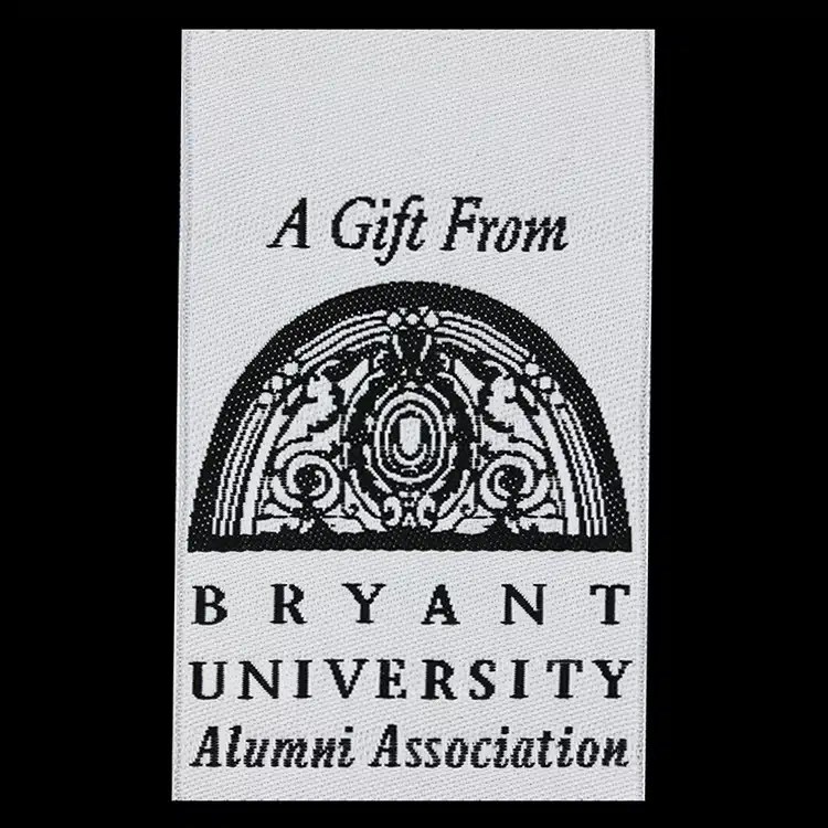 A Gift From Bryant University Alumni Association woven label with an archway graphic, black lettering on white.