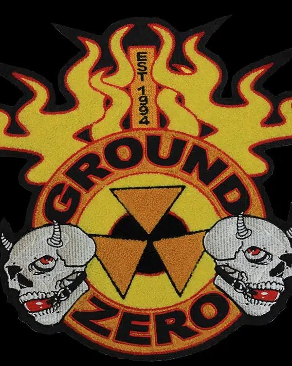 Die-cut back patch with yellow and orange chenille flames, two embroidered skulls and a radiation symbol, on a black background.